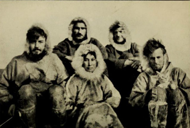 The 1921 Wrangel Island expedition team pose in parkas. Left to right: Allan Crawford, Ada Blackjack, Lorne Knight, Fred Maurer, and Milton Galle who holds Vic the cat.