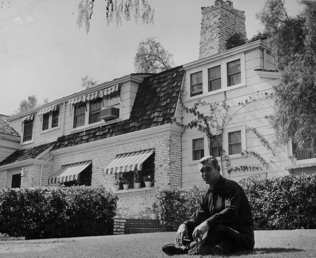 Clark Gable sitting in the garden of his home in Encino 