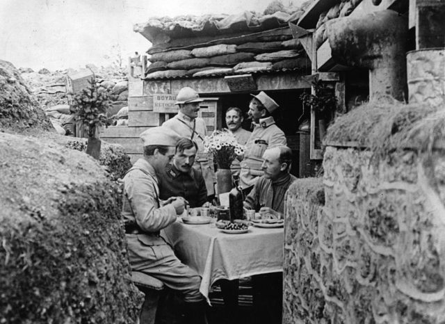 French officers gathered around a table decorated with flowers
