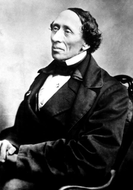 Hans Christian Andersen sits with his hands folded in his lap