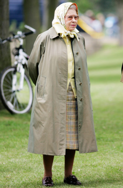 Queen Elizabeth II standing in a rain coat