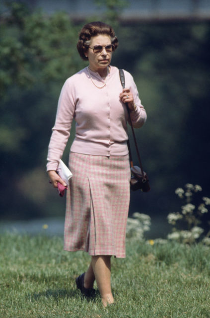 Queen Elizabeth II walking through the grass