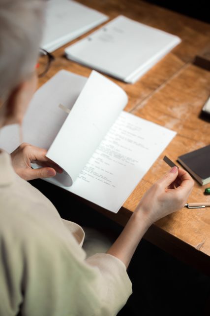 a woman looking through some manuscripts