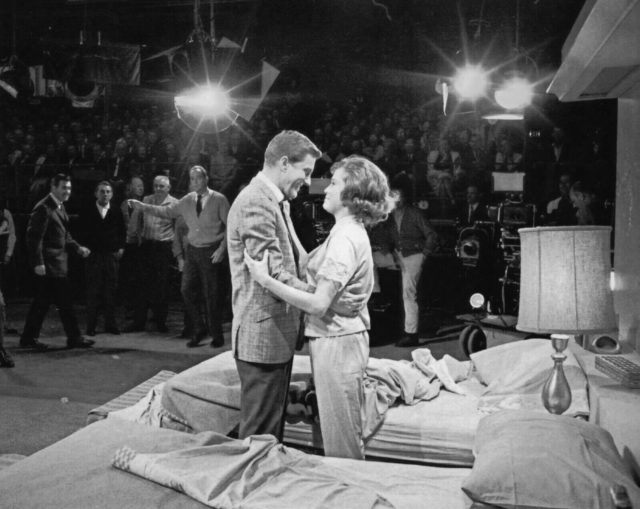 Dick Van Dyke and Mary Tyler Moore embrace in front of the studio audience while filming "The Dick Van Dyke Show".
