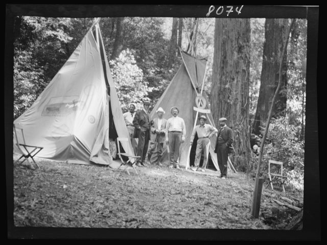 Bohemian Grove scene in front of tents 