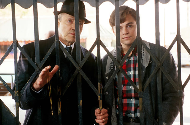 Movie still of Christopher Walken and Leonardo DiCaprio behind an iron fence in Catch Me If You Can