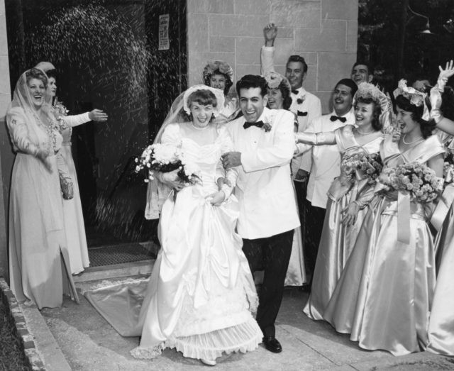 A bride and groom are showered in rice as they leave the church