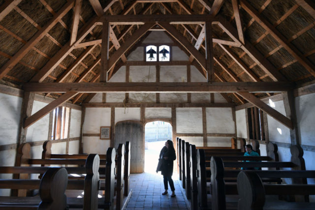 Visitors explore a re-created church from the Jamestown settlement.