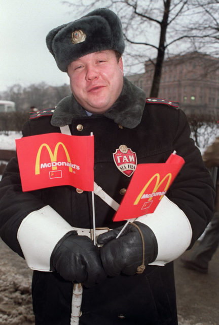 A man holding two little McDonald's flags
