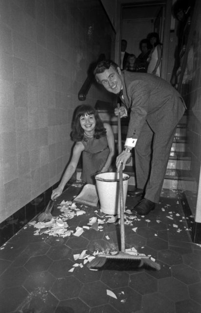 Bride and groom sweeping broken dishes