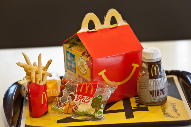 Image of a McDonalds Happy Meal including fries, apple slices, and a milk carton