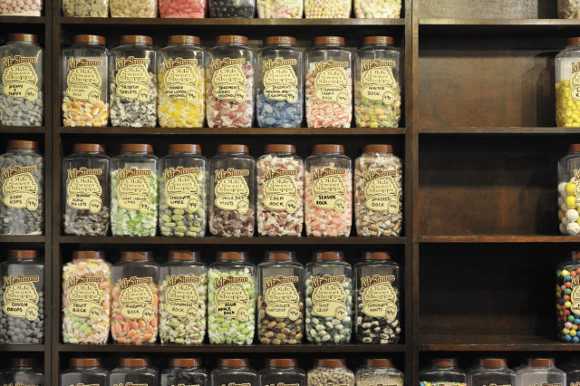 Candy jars lined on a shelf.