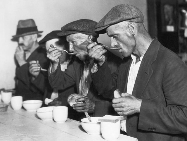 Men eating bowls of soup