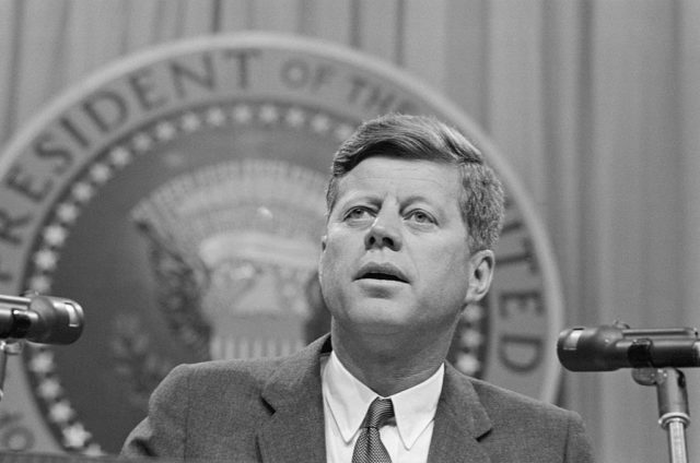 John F. Kennedy speaking behind a podium