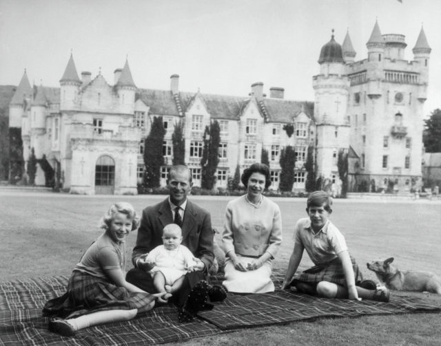 Black and white photo of the royal family picnicking in front of Balmoral Castle