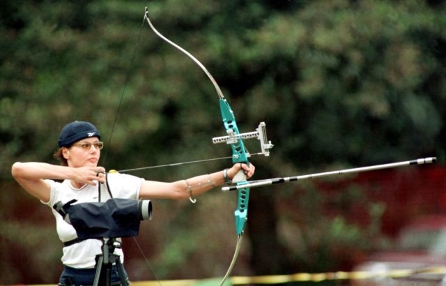 Geena Davis preparing to shoot an arrow
