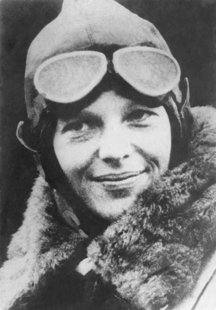 Black and white photo of Amelia Earhart in pilot headgear