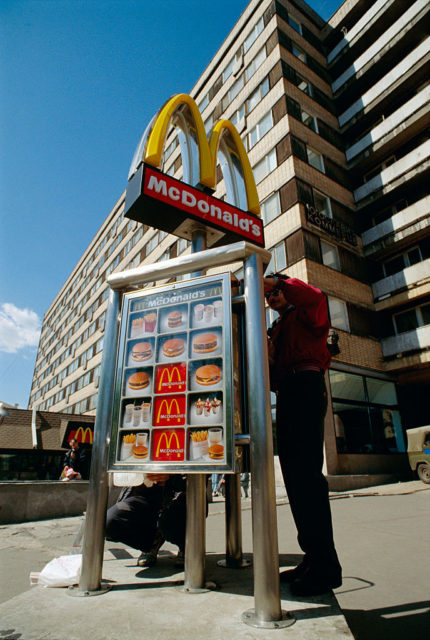 Two men installing a McDonald's sign outside