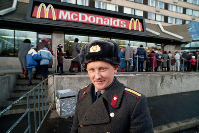 A Russian policeman stands by a line of people