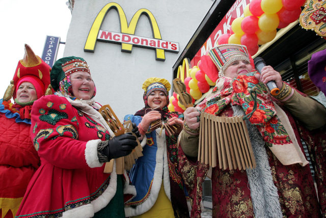 Traditionally-dressed Russian musicians standing outside McDonald's
