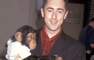 Alan Cumming holding Tonka the chimpanzee in his arms