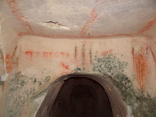 Cave entrance with red lettering overtop