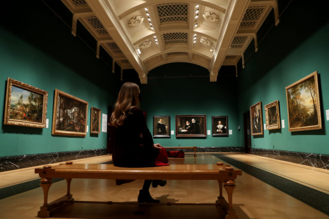 Woman sitting on a bench in the middle of the Queen's Gallery