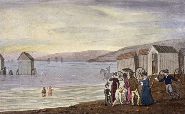 A painting depicts bathing machines by the sea side
