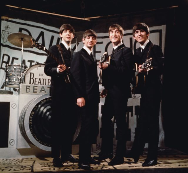 the beatles holding guitars