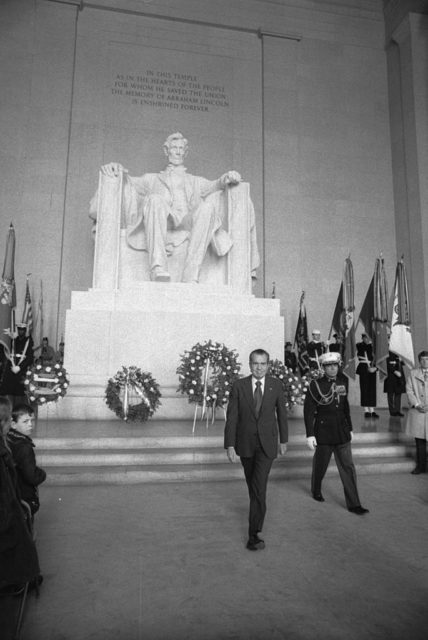 Richard Nixon walking away from the statue of Abraham Lincoln
