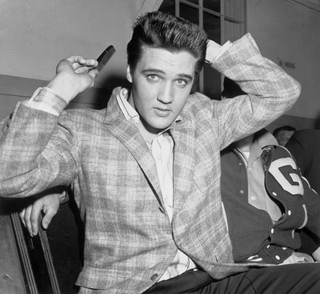 Elvis Presley combs his hair