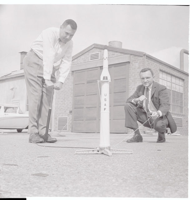 Two men set up to test a toy rocket.