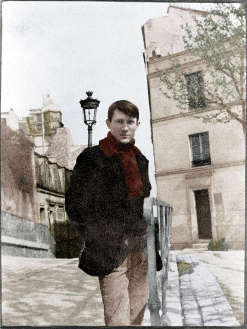 Coloured image of a young Pablo Picasso standing on a French street.