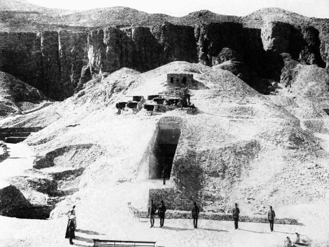 Black and white photo of entrance to King Tut's tomb in the side of a mound.