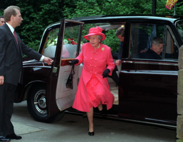 Queen Elizabeth arrives at an event in Wales in a bright pink ensemble. 