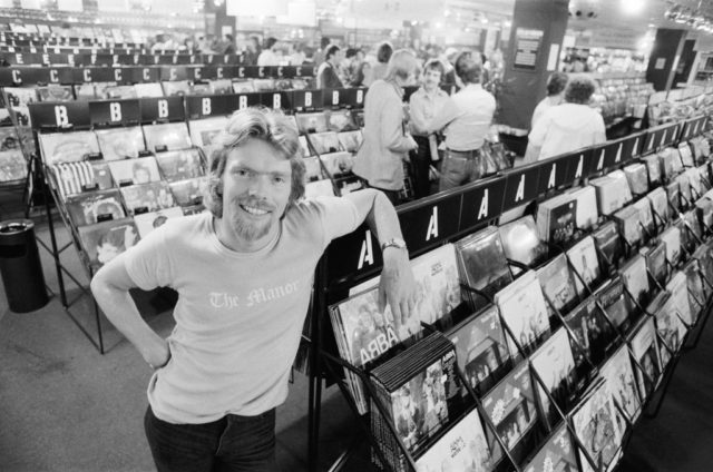 Richard Branson poses with a record display at his Virgin Music store.