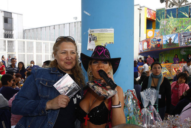 Coloured photo of two women standing together, one of them is holding a CD.