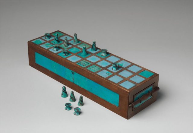 Coloured photo of an Egyptian gameboard and pieces made from wood and blue faience, which looks like turquoise stone.
