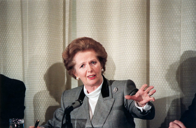Margaret Thatcher holds out her hand at a press conference