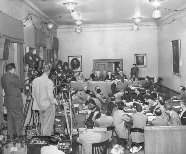 Two cameramen film the unfolding scene in a crowded courtroom during the Kefauver Committee hearings