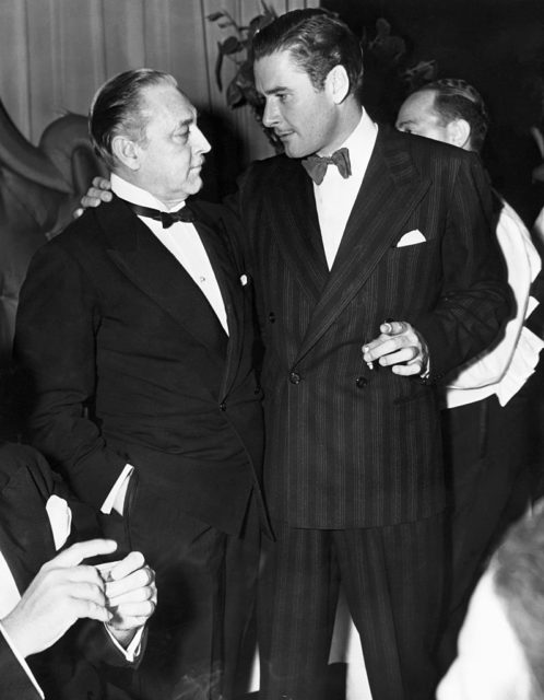 John Barrymore and Errol Flynn stand side by side at an event
