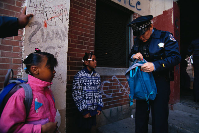 A police officer searches backpack