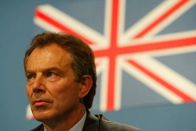 Tony Blair in front of the flag of Britain