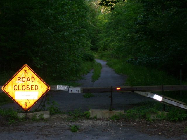 A road closed sign on a barrier