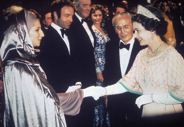 Barbra Streisand shaking hands with Queen Elizabeth II