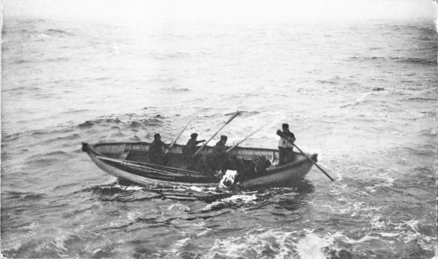 Crewmen paddling a boat in the middle of the Atlantic Ocean