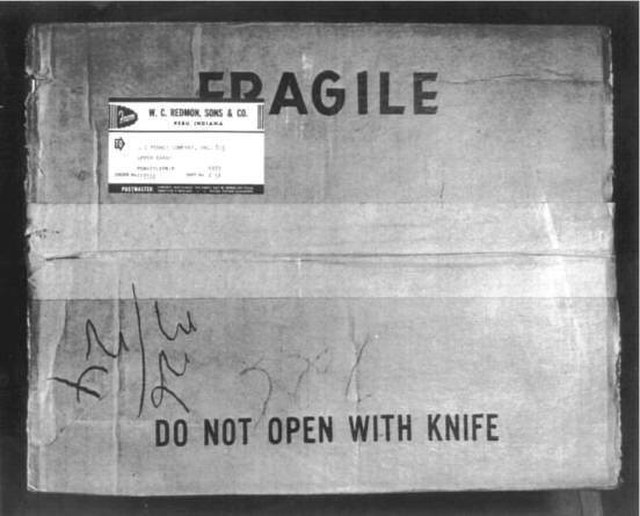 Cardboard box with "FRAGILE" and "DO NOT OPEN WITH KNIFE" printed on the top
