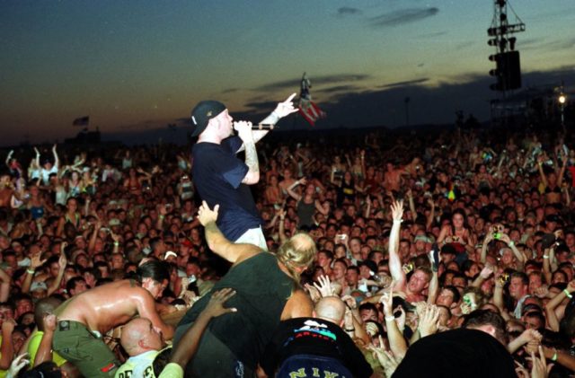 Fred Durst performing in front of a large crowd at Woodstock '99