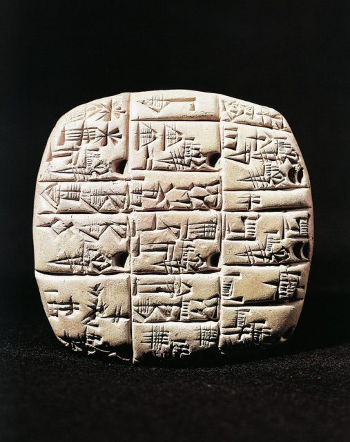 Square clay tablet with rounded edges with cuneiform characters etched into it.