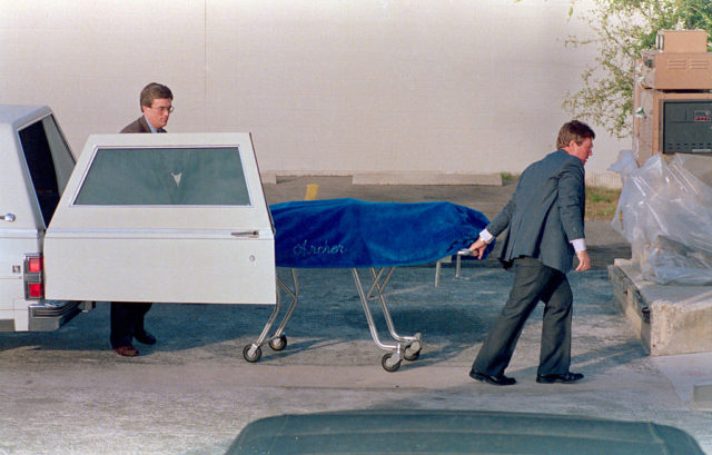 Two men unload a gurney with the body of Ted Bundy following his execution 